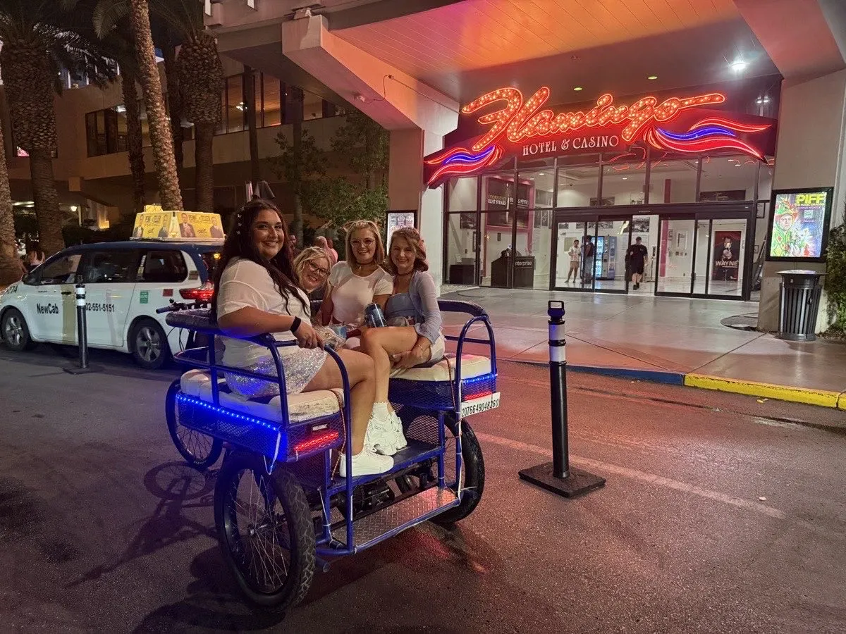 Riders seated in a Vegas Bike Cab pedicab outside the Flamingo on the Strip